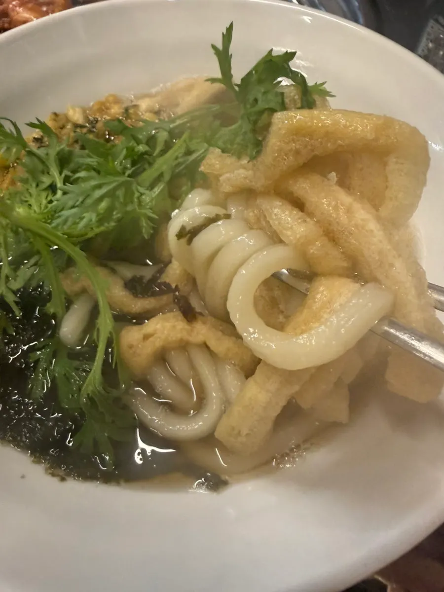 A bowl of udon served alongside the grilled meat