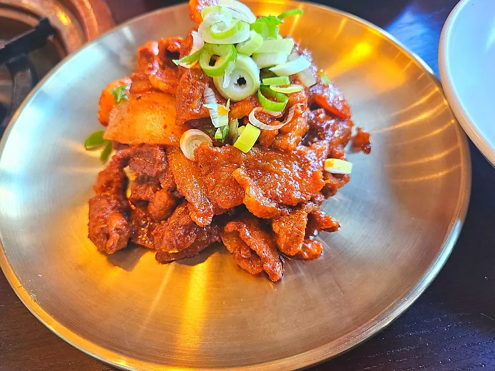 Stir-fried pork topped generously with green onion