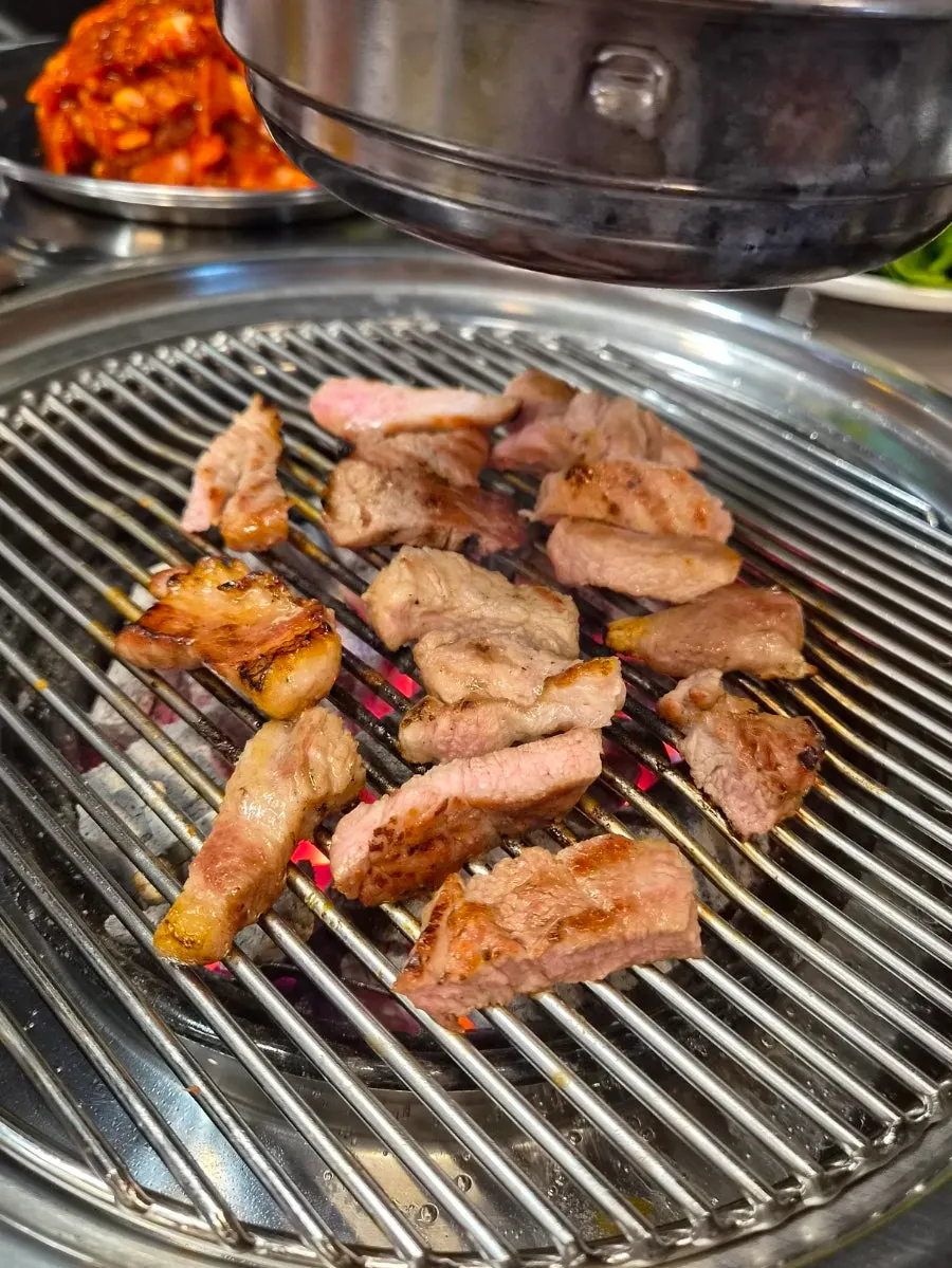 Pork neck cooking over charcoal