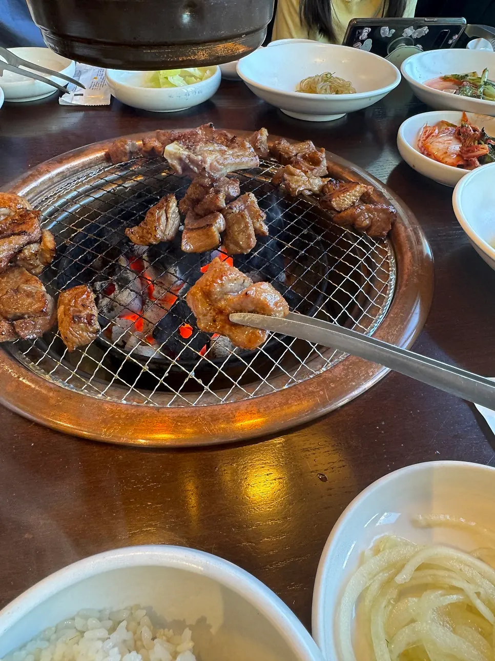 Grilled pork galbi picked up with meat tongs
