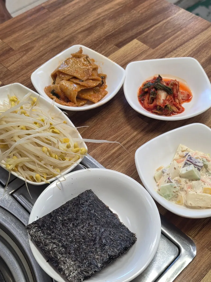Plates of salad and spicy fish cake side dishes