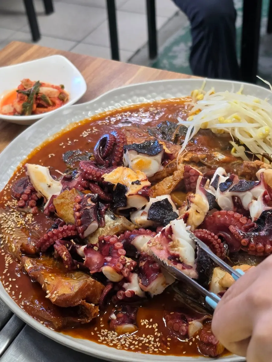 A piece of chewy octopus picked up with chopsticks