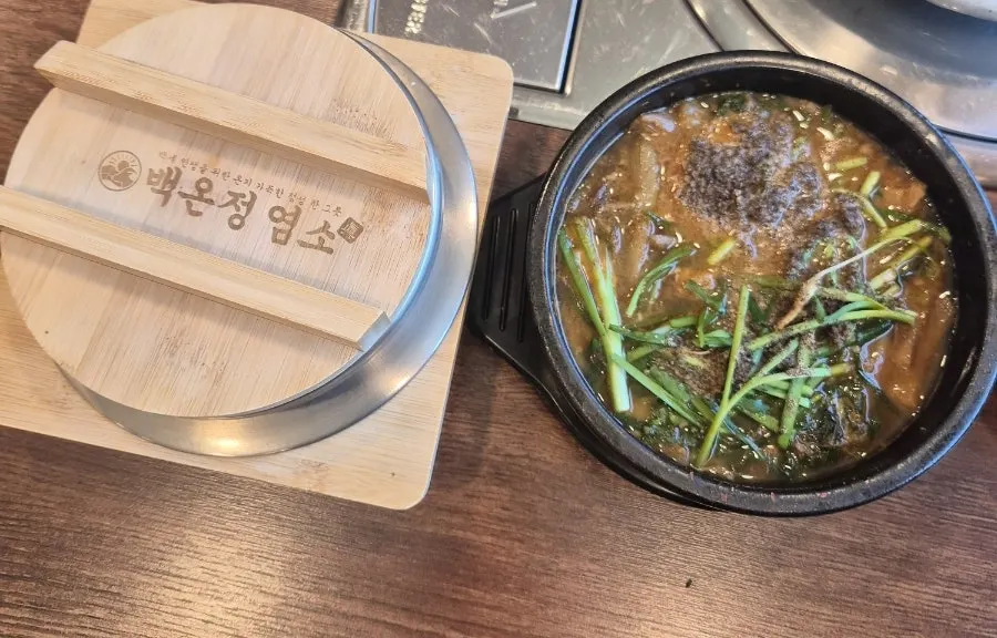 깻잎 미나리 들깨가루가 올라간 염소탕