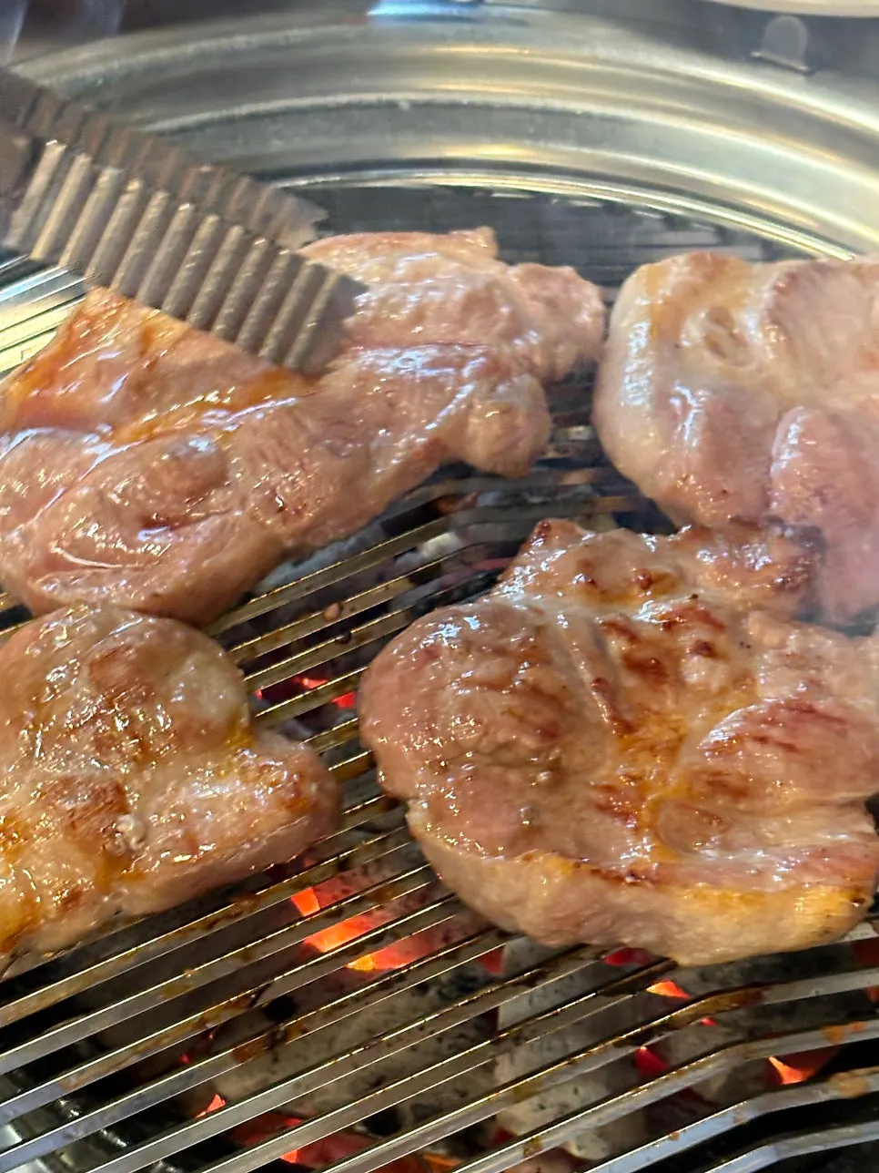 Raw pork neck grilling on the charcoal grill