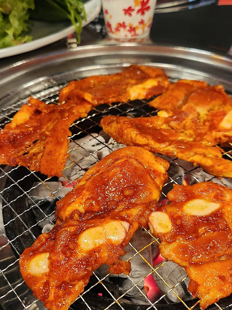 Red raw pork belly cooking to a golden brown