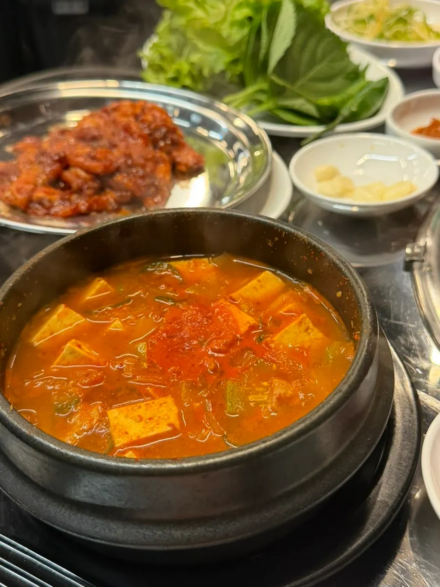 Trozo de panceta roja sobre el bibimbap en cazuela