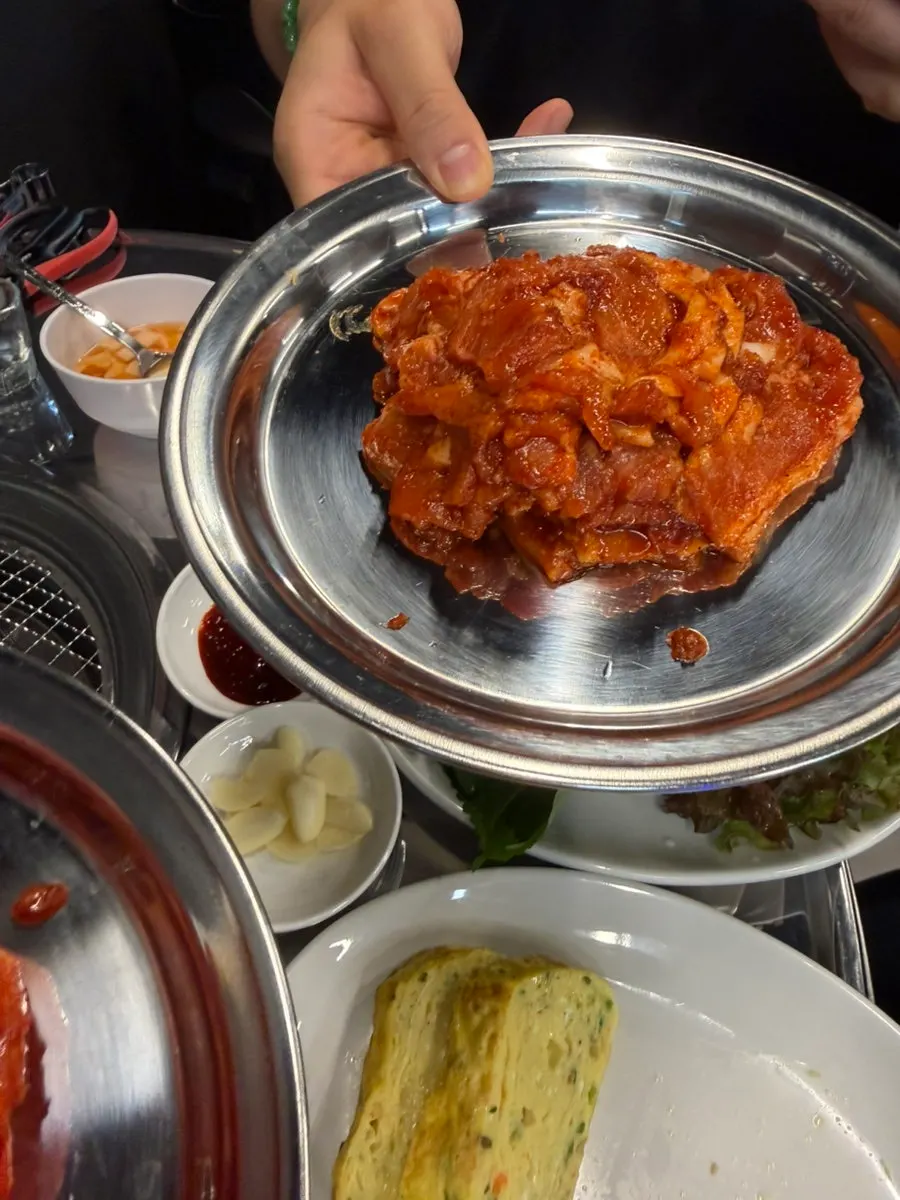 Table set with spicy raw pork belly and soju