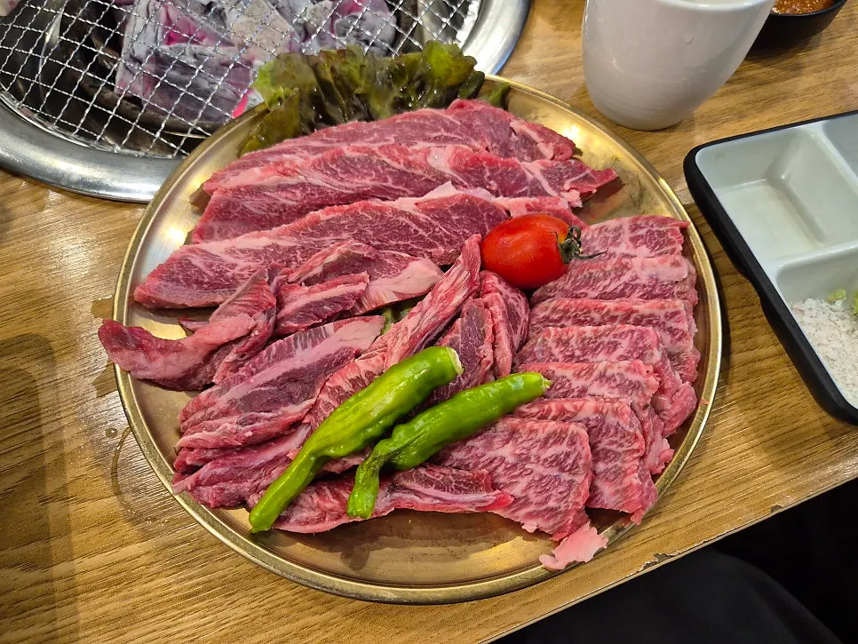 숯불 위에 올려진 고기와 곁들임