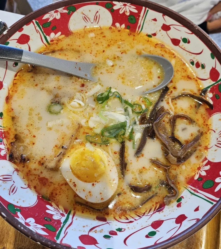 Karai ramen topped with scallions and minced garlic