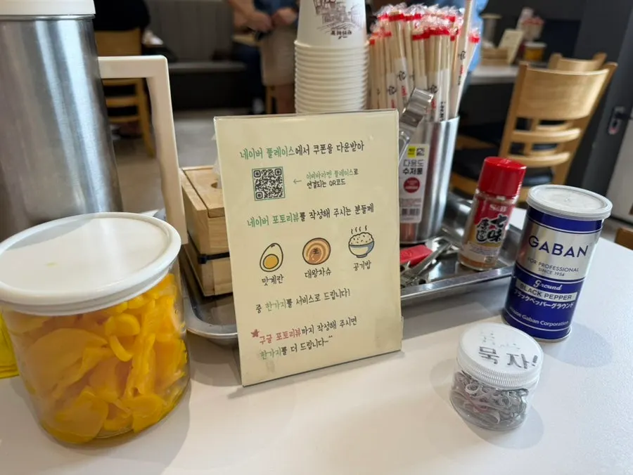 Table at Ichiba Ramen set with pickled radish and shichimi pepper