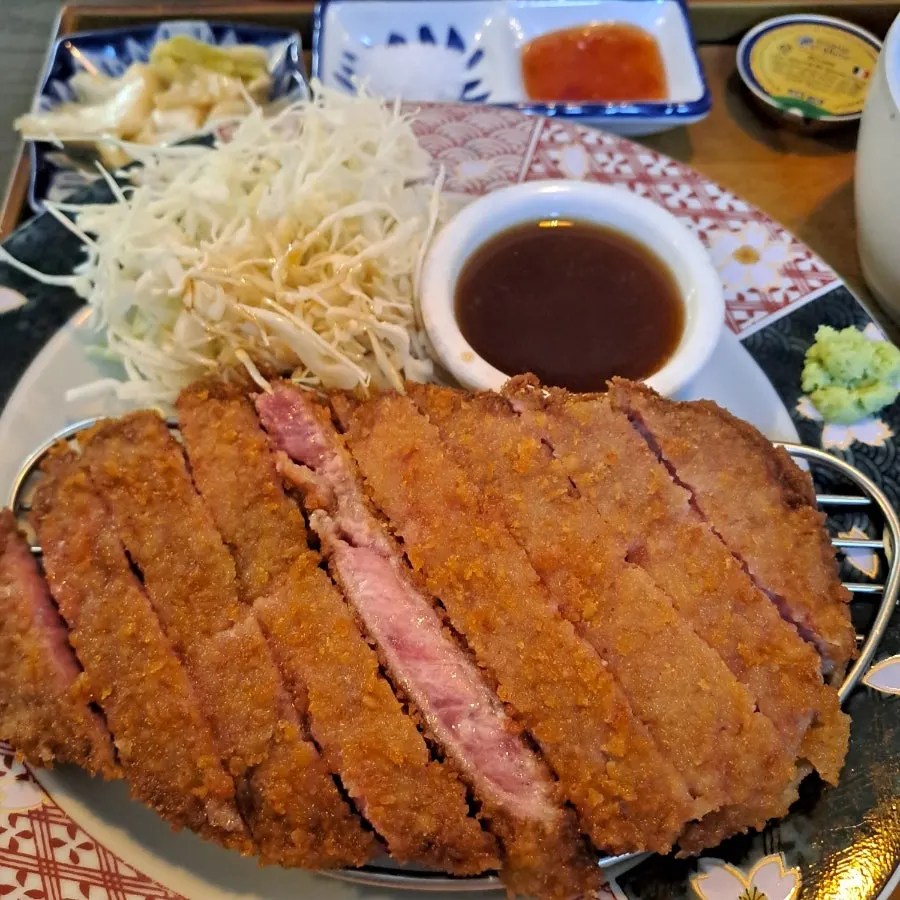 A grilled piece of tenderloin gyukatsu off the brazier