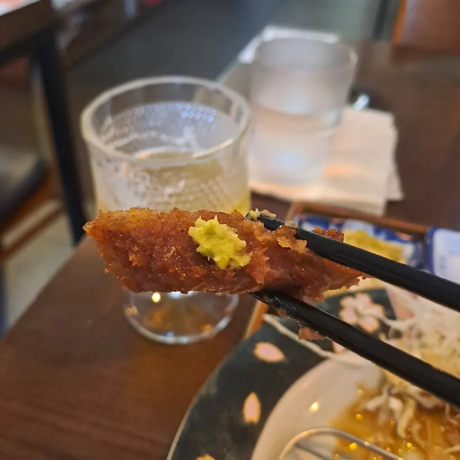 Gyukatsu topped with wasabi alongside the special sauce