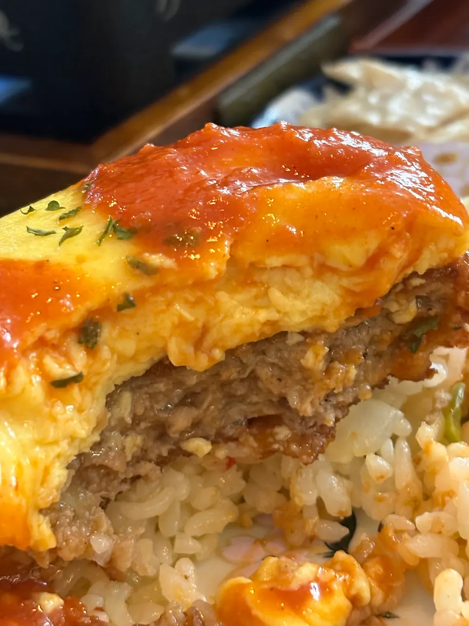 A piece of hamburg omurice drizzled with sauce
