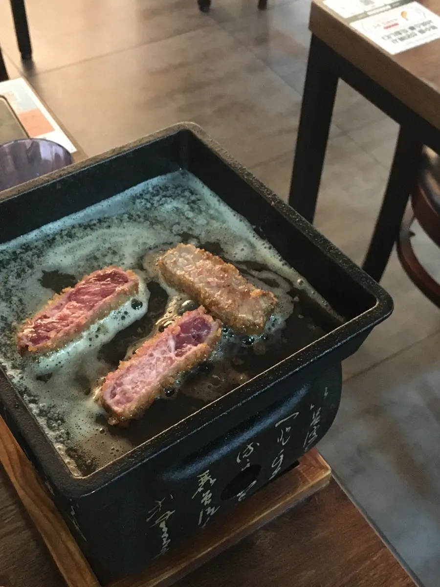 Grilling gyukatsu on the butter-melted brazier