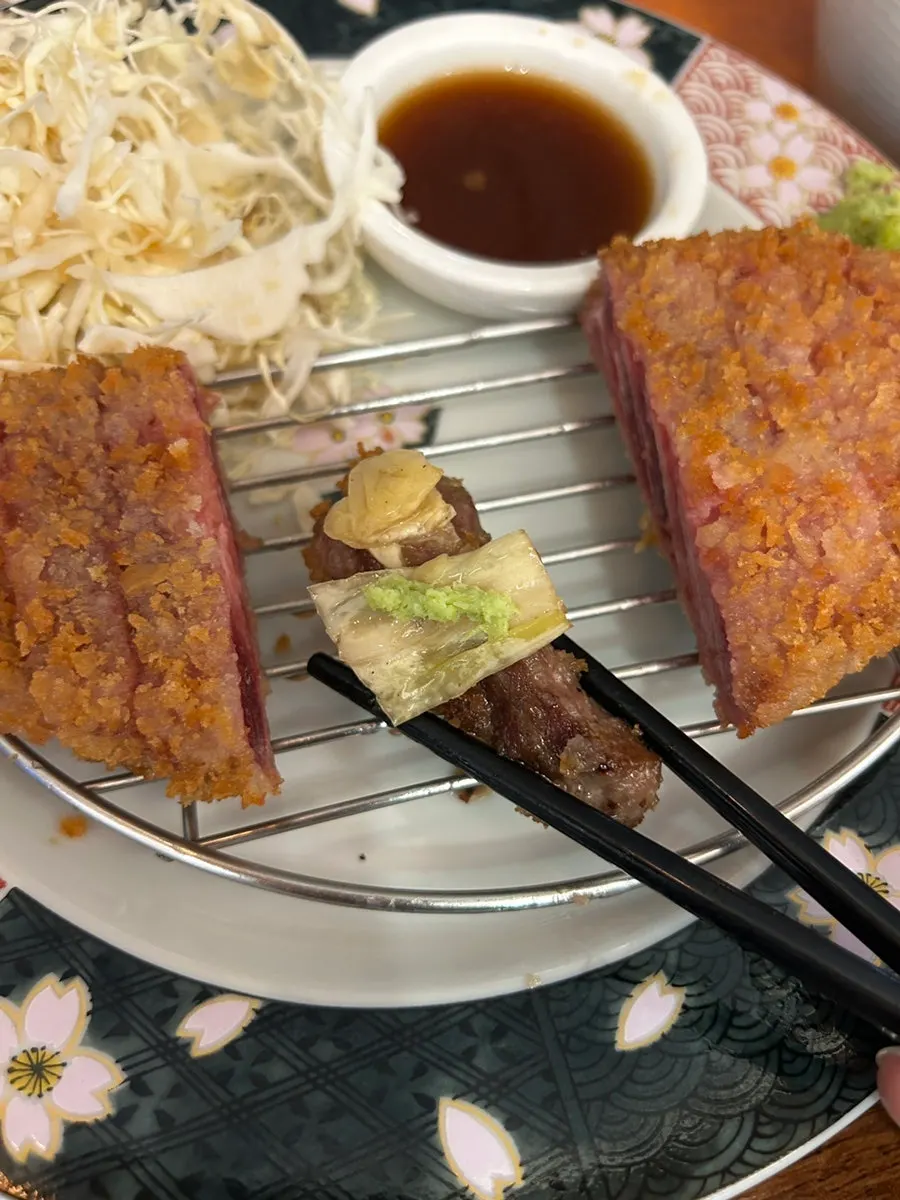 A piece of gyukatsu with sauce on the side