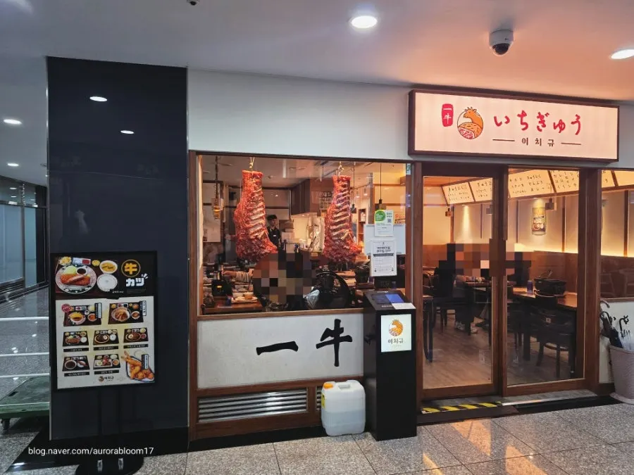 Entrance interior of Ichigyu Seoul Station Branch with hanging meat