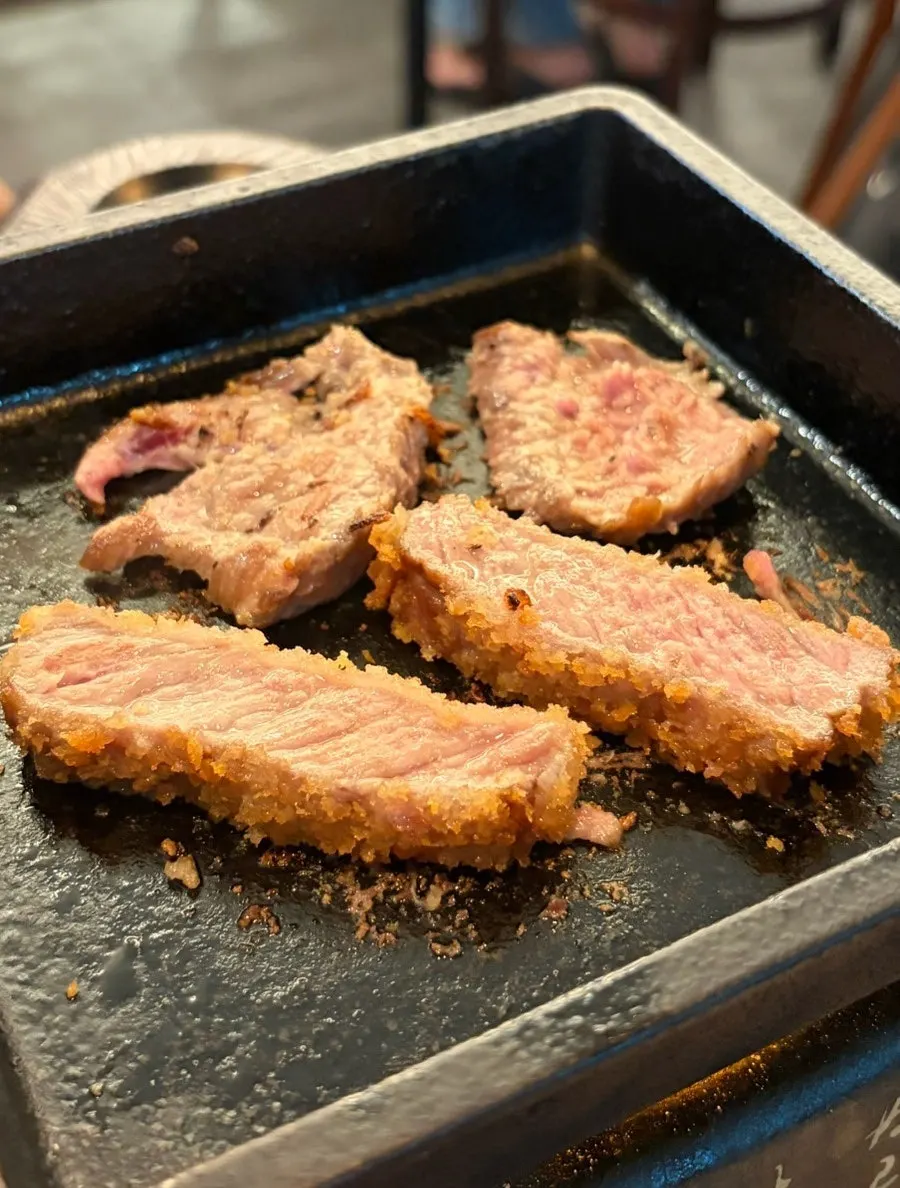 A piece of sirloin grilling on the brazier