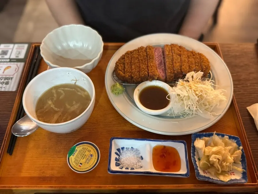 Table with salad, sauce, and fried tofu soup served alongside the mains