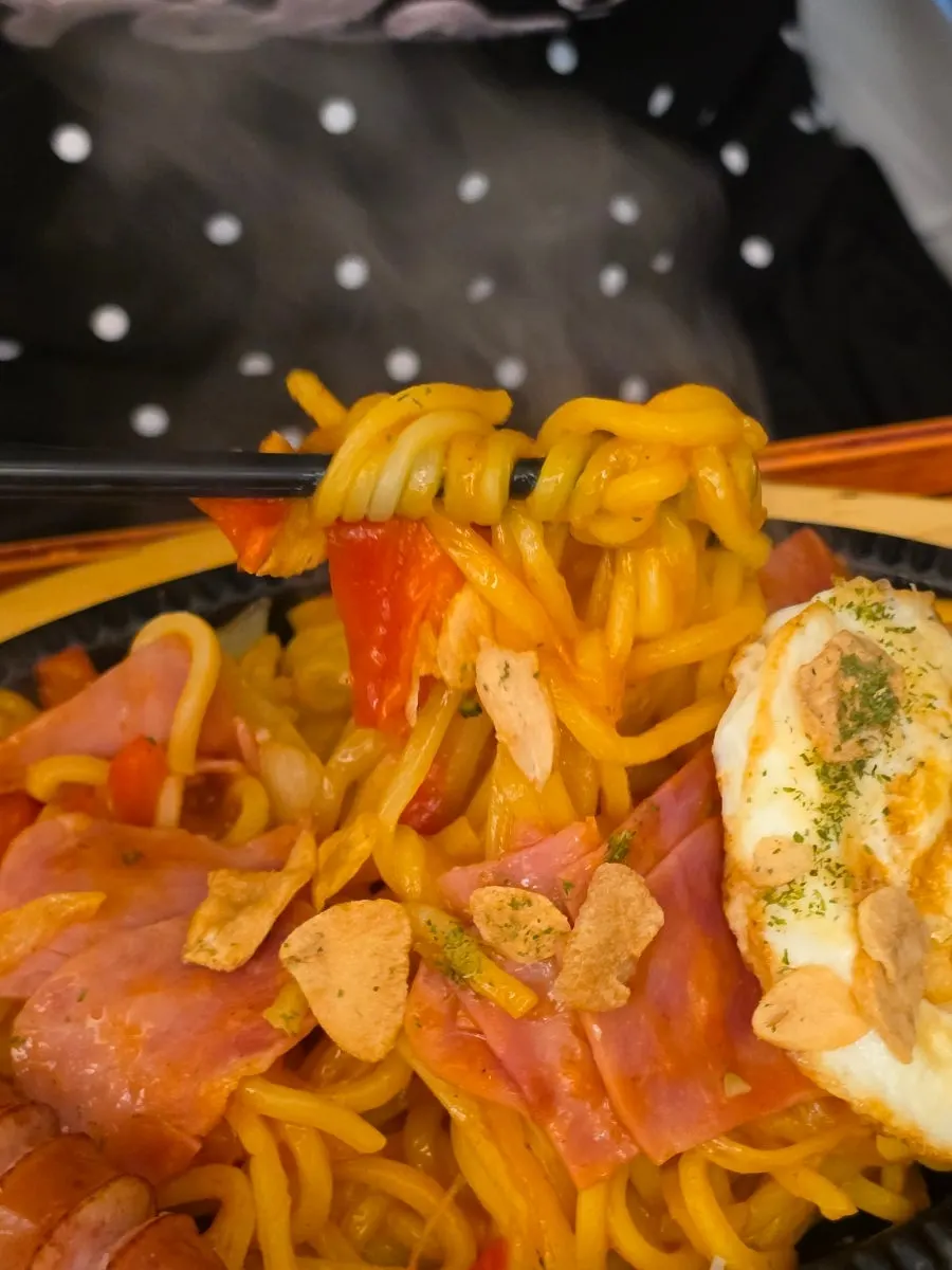 Yakisoba Napolitan topped with a whole sausage