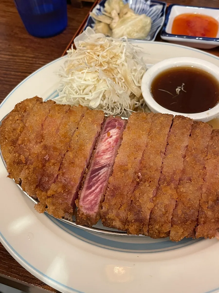 얇은 튀김옷 속 채끝 마블링이 보이는 규가츠 단면