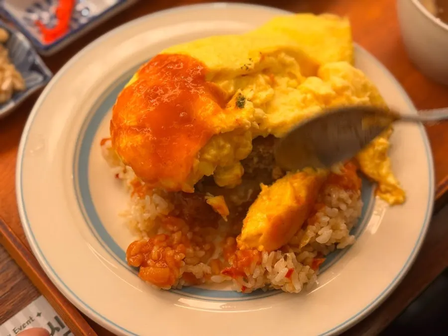 Hamburg steak patty revealed inside the omurice with a spoon