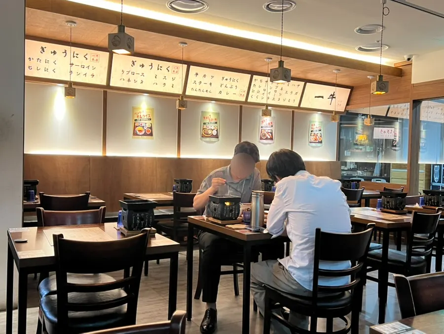 Interior of Ichigyu Seoul Station Branch with wood-toned tables
