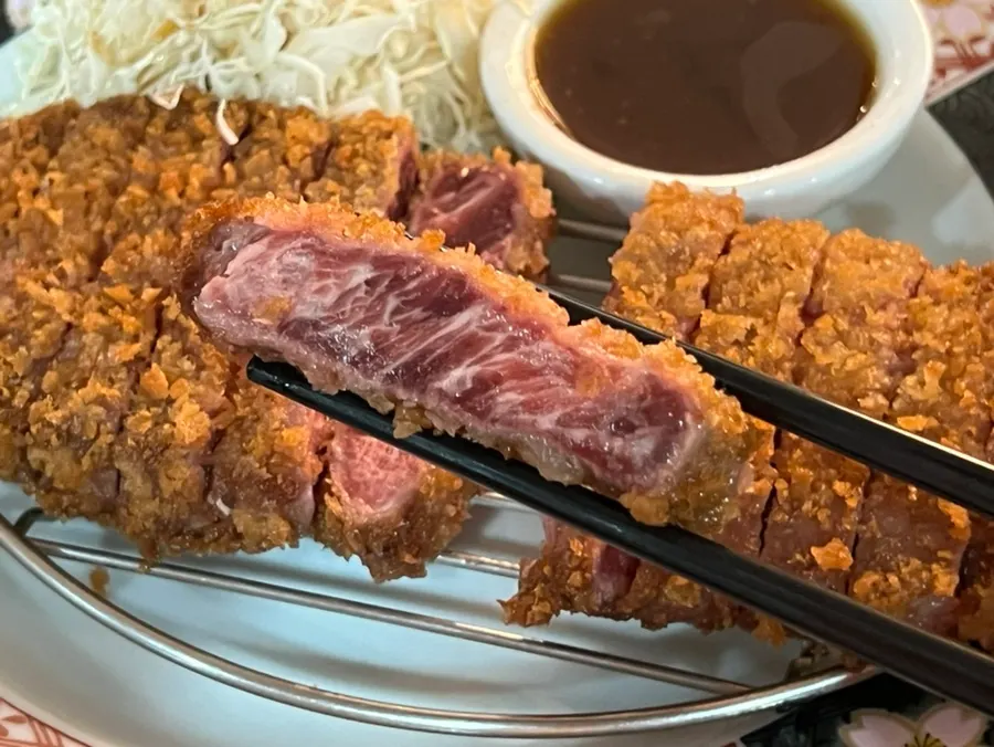 A piece of gyukatsu placed on the grill