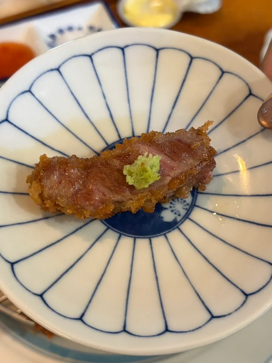 A bite of steki topped with wasabi