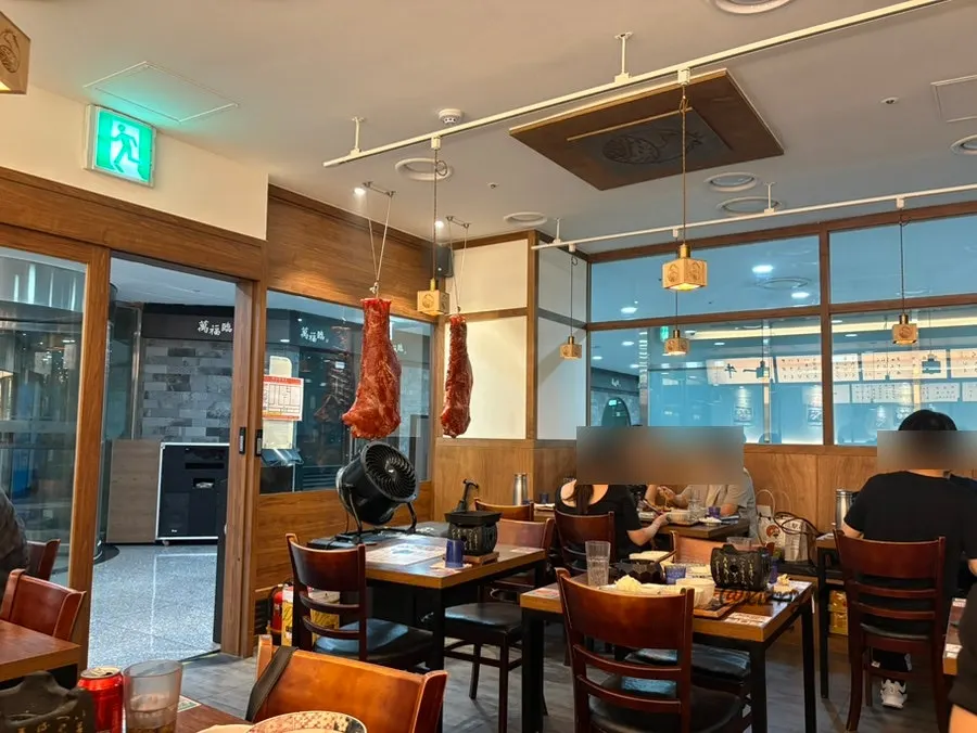 Interior of Ichigyu Seoul Station Branch with wood-toned tables