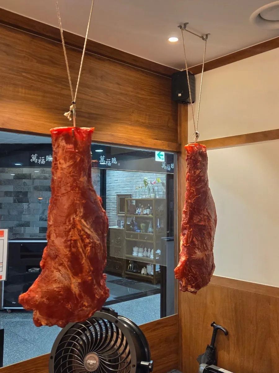 Large hunk of meat hanging as decoration outside the restaurant
