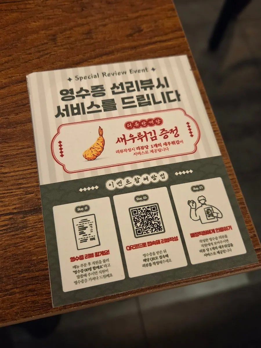 Sign announcing free deopae-mochi and fried shrimp with the review event
