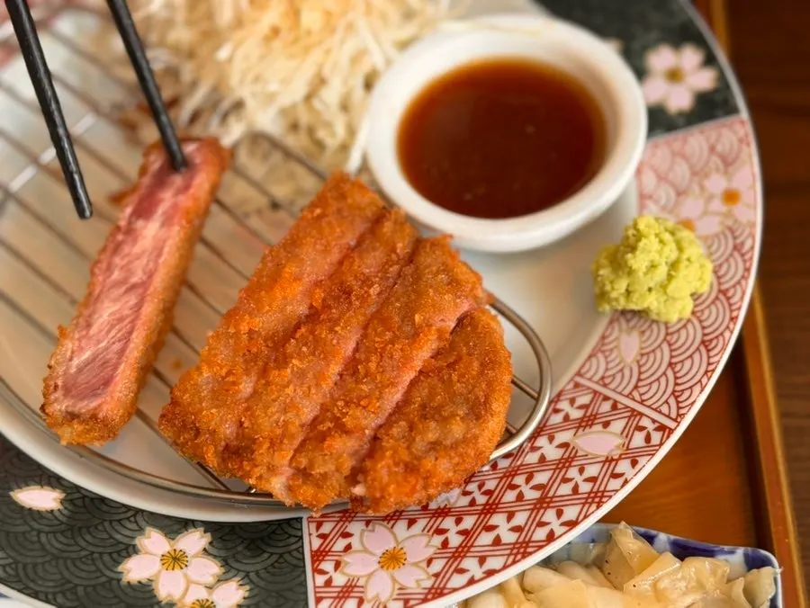 A piece of gyukatsu dipped in sauce
