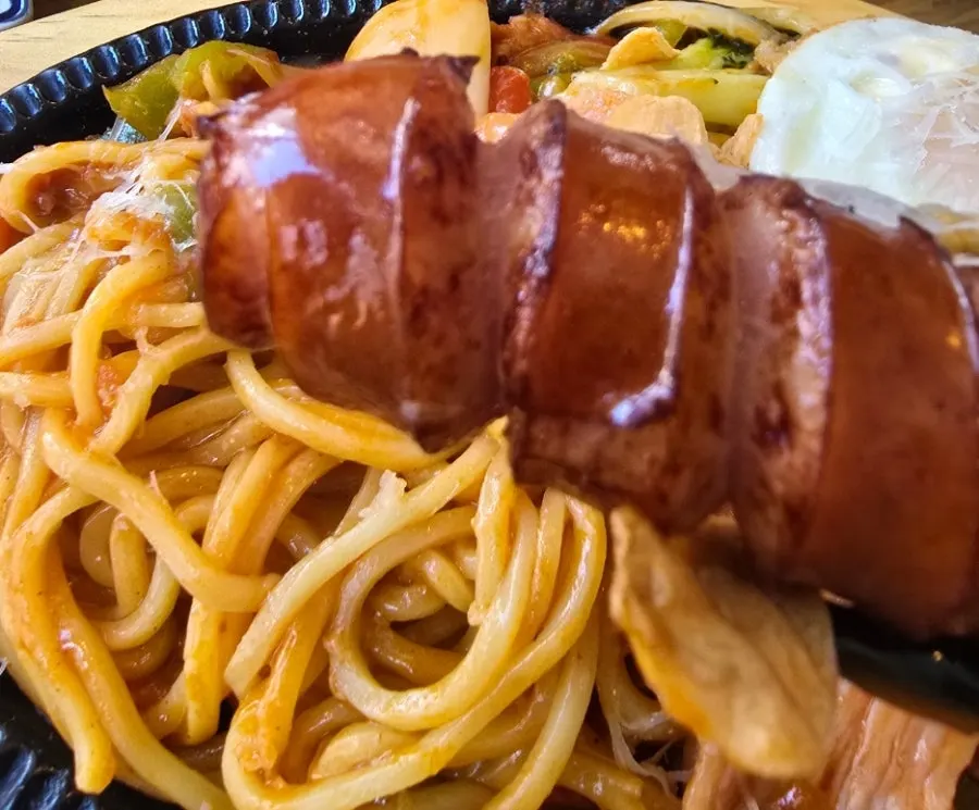 Stir-fried Napolitan noodles topped with scored sausage and cheese
