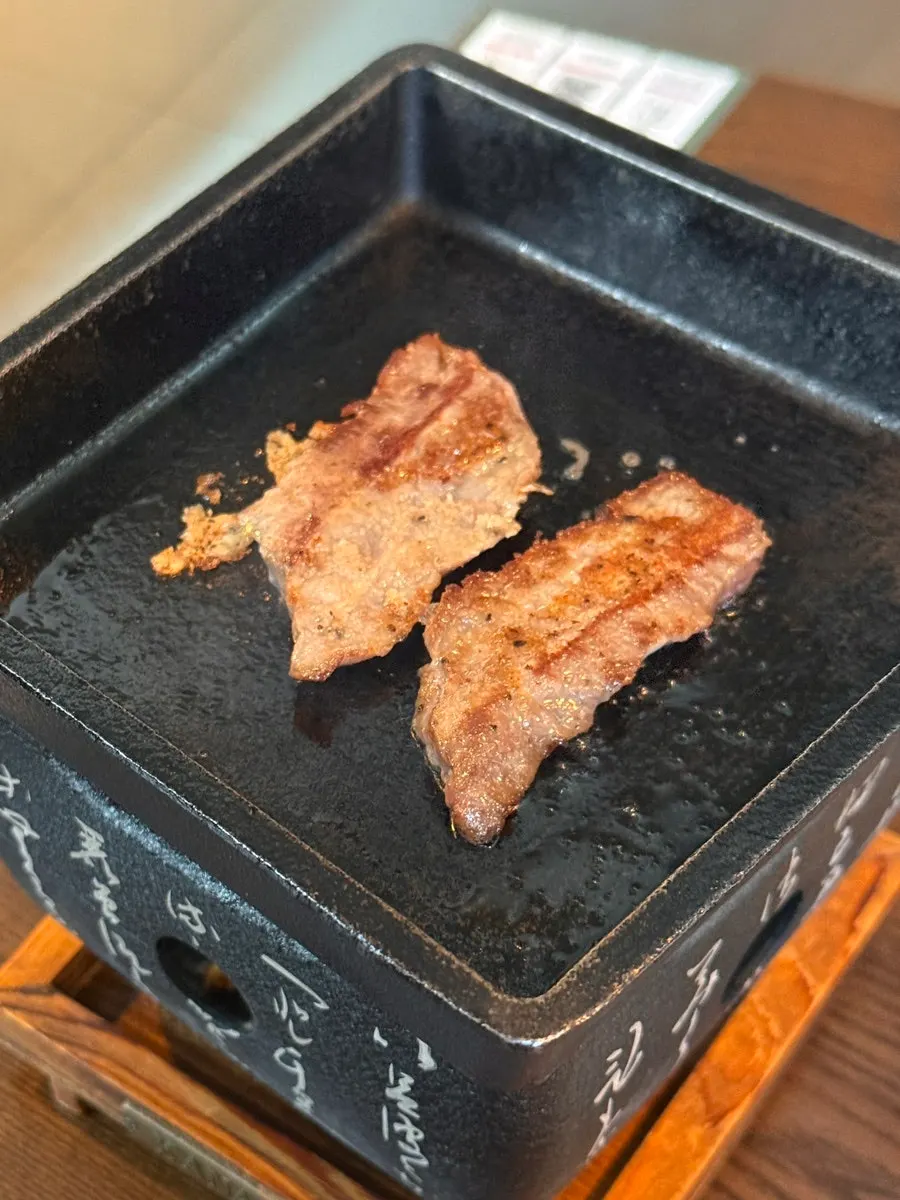 A piece of steki sizzling as it cooks