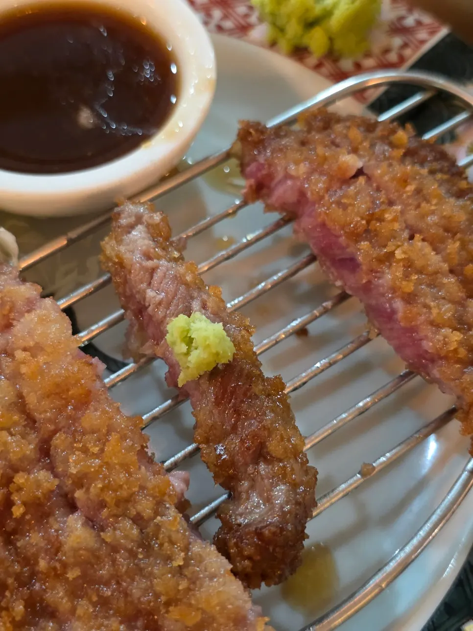 A piece of gyukatsu eaten with rice