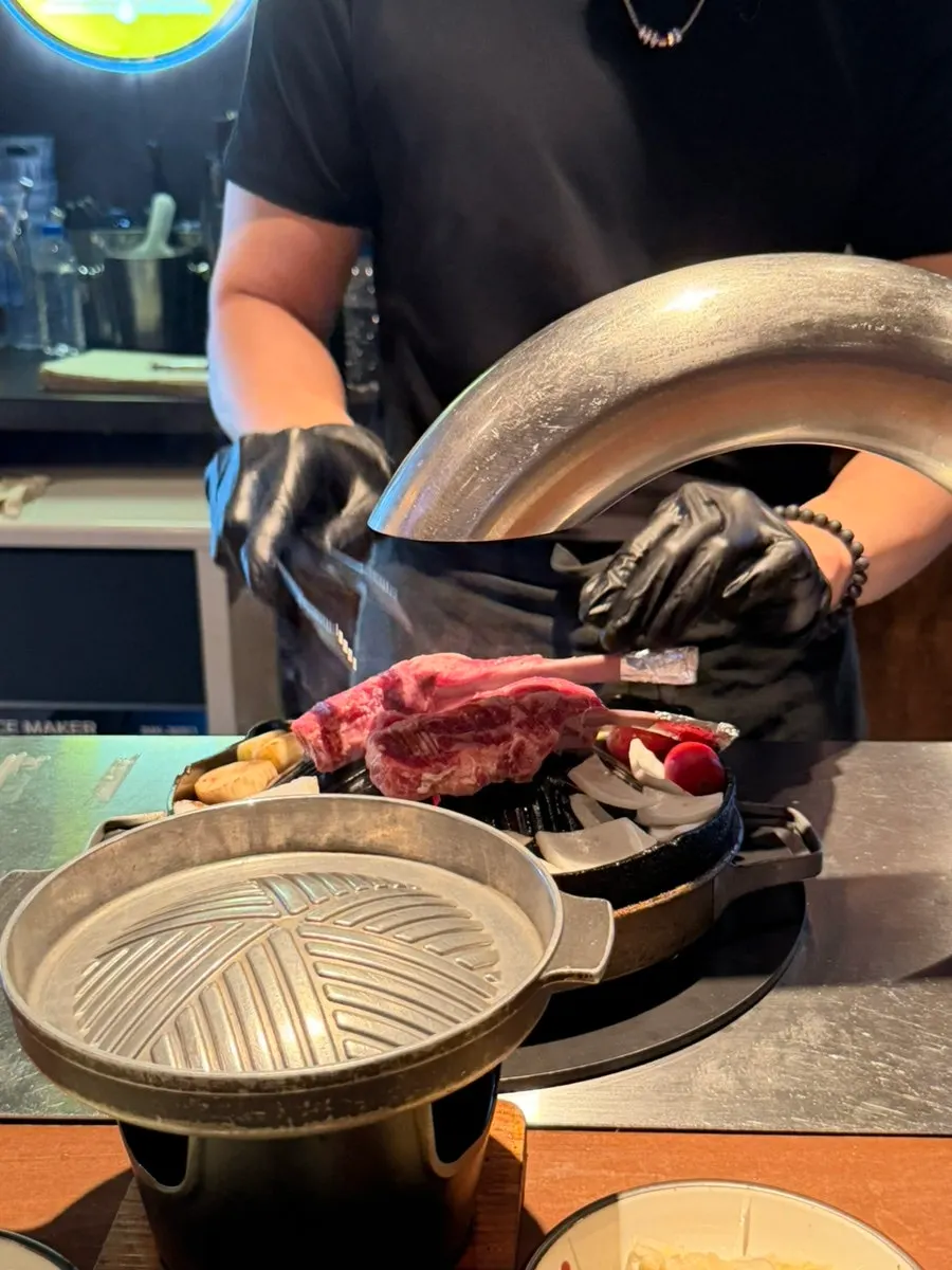 Staff member grilling the lamb ribs