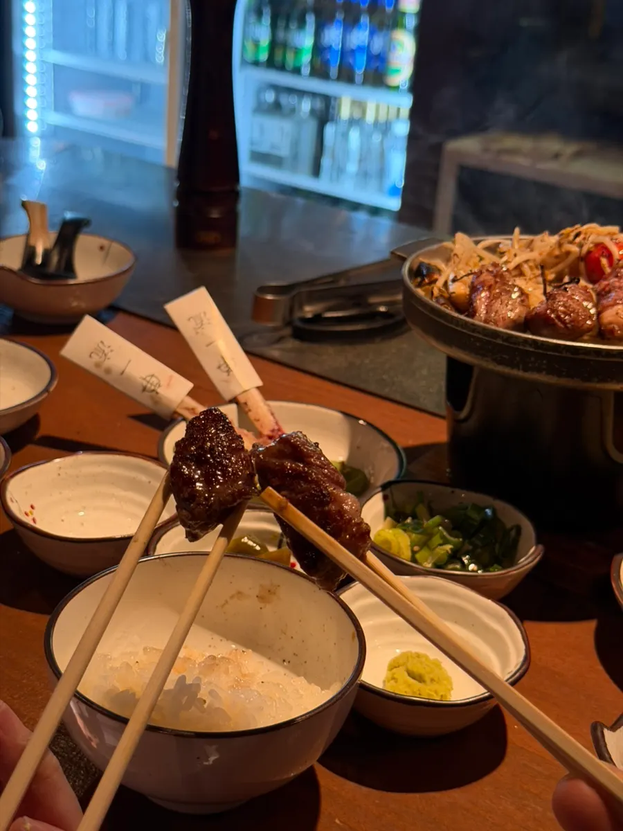 Lamb rack with a paper handle served alongside baekkimchi