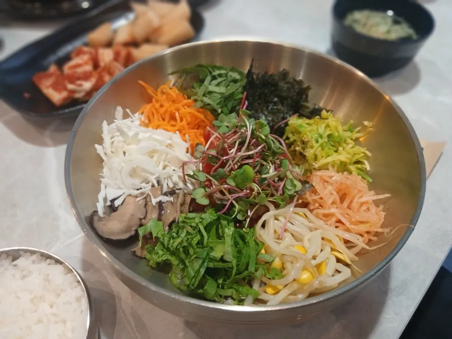 Bowl of raw beef bibimbap mixed with seasoning
