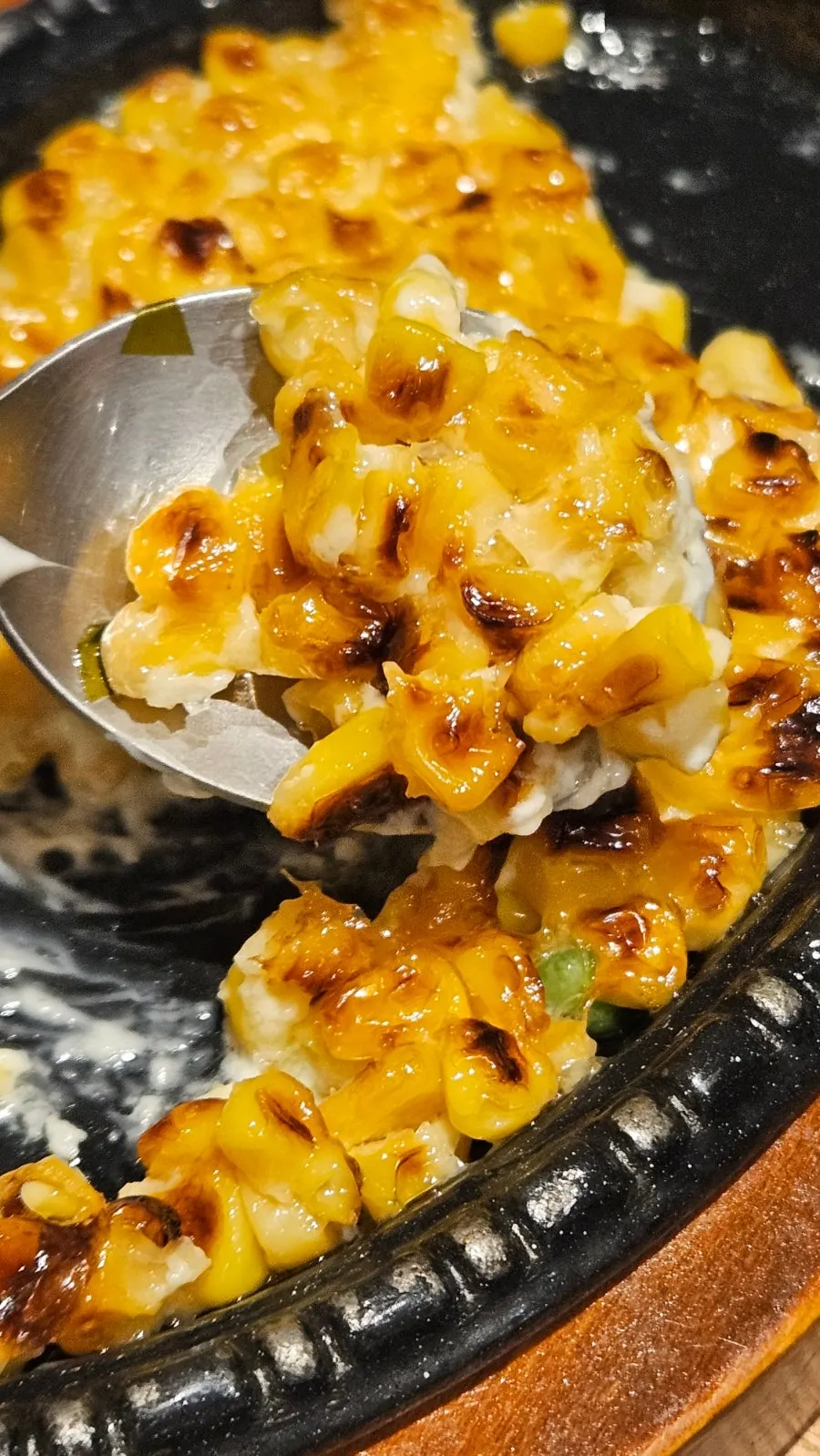 Scooping up corn cheese with a spoon