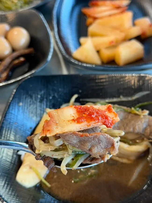 A bite with rice cake and dried radish salad