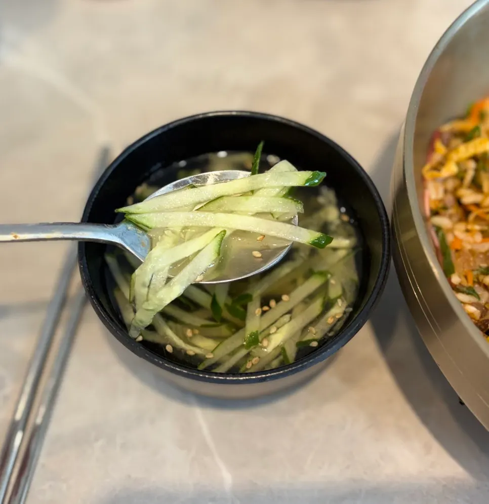 A spoonful of chadolbak bibimbap topped with kimchi
