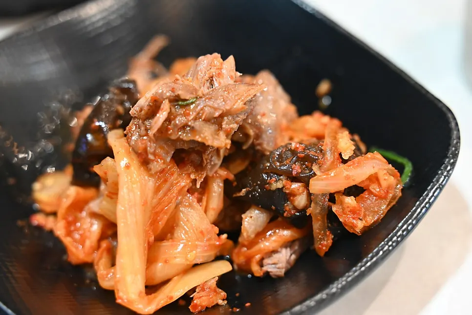 갈비 위에 김치를 올려 먹는 모습