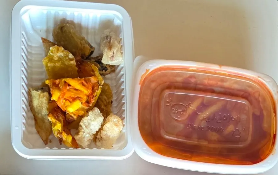 Fried snacks in a paper bag with packaging containers