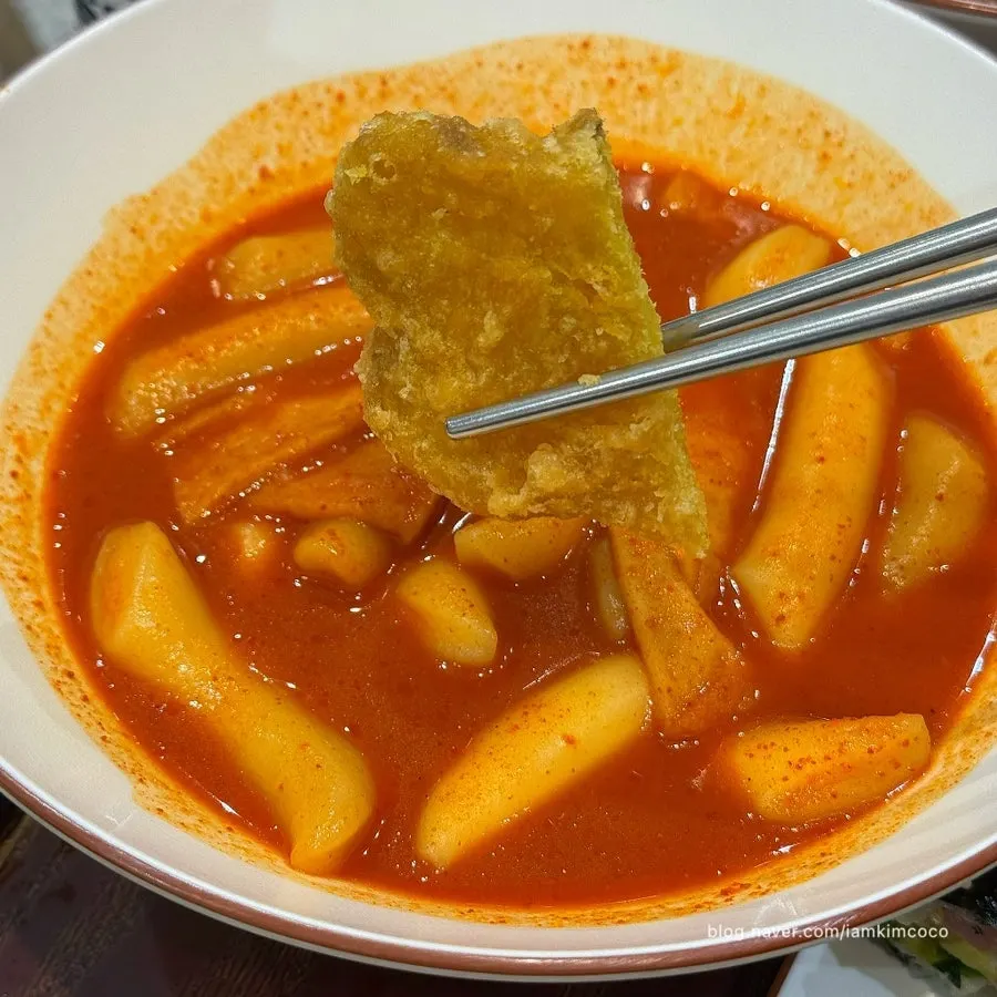 Sweet potato tempura dipped into tteokbokki sauce