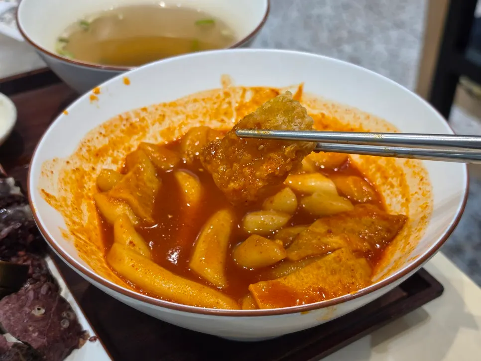Crispy fried snack dipped in tteokbokki broth