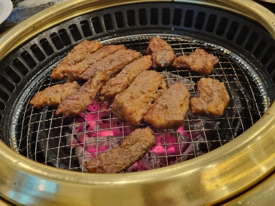 Staff grilling marinated meat on the grill