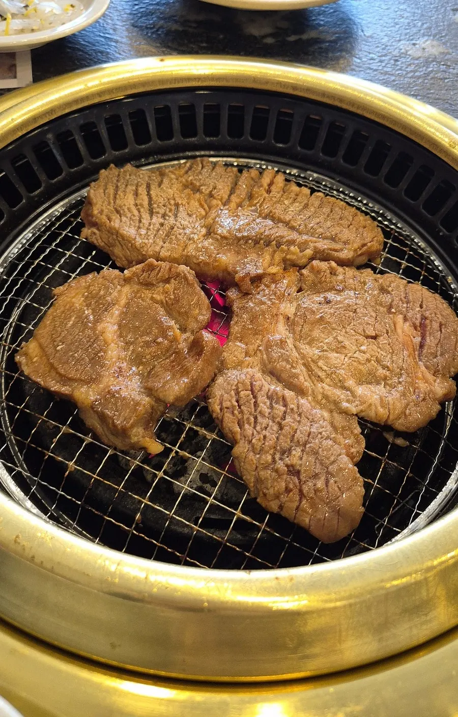 Marinated ribs being grilled with pear juice poured over