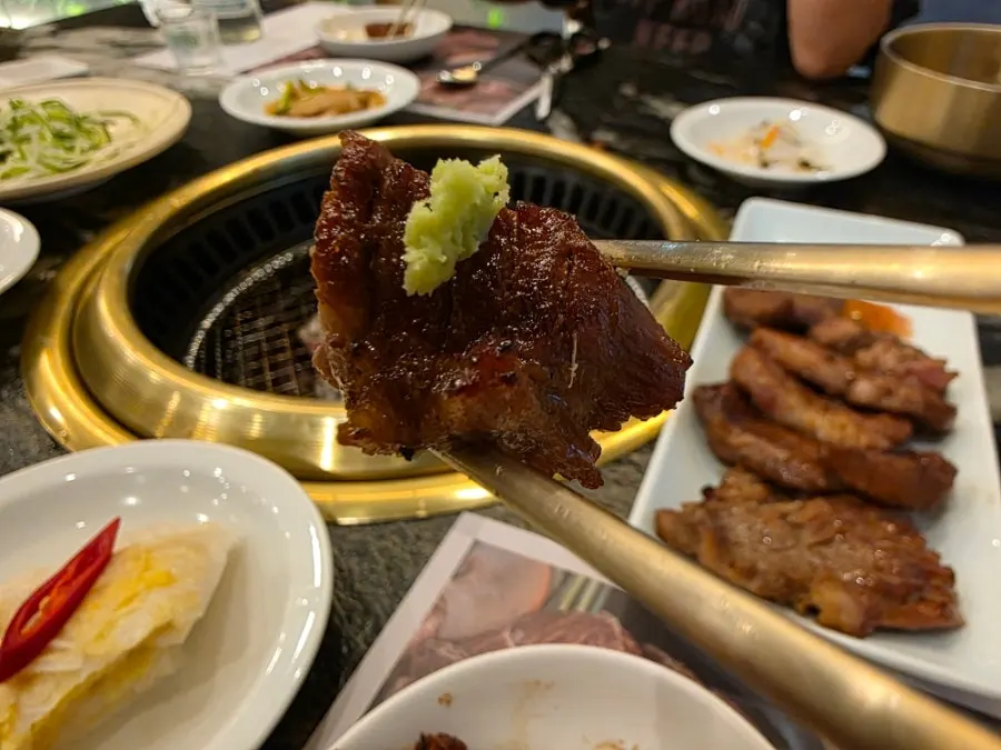 A tender piece of pork galbi picked up with chopsticks