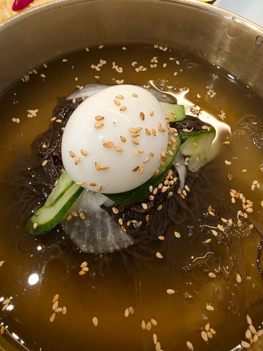 Water naengmyeon topped with cucumber, pear, and egg