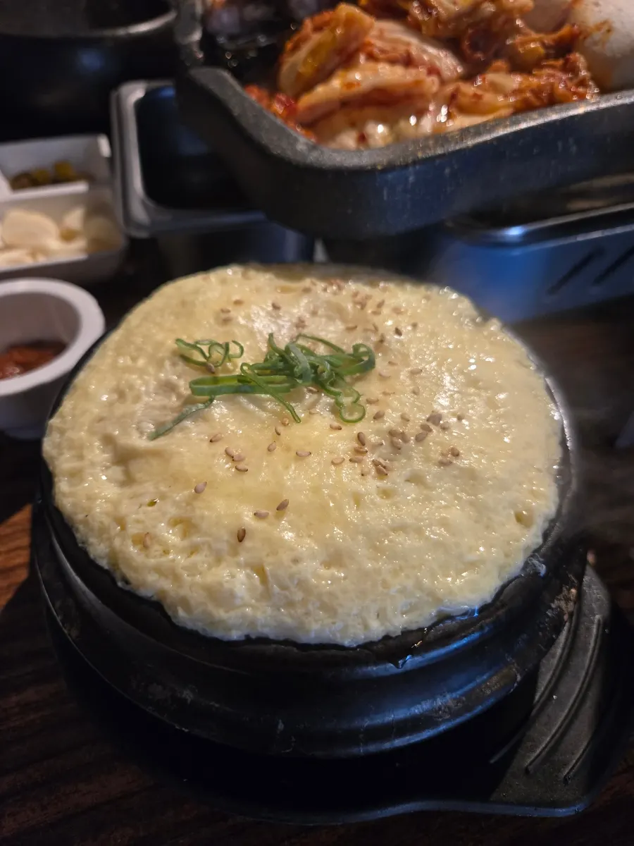 Fluffy steamed egg puffed up over the stone pot